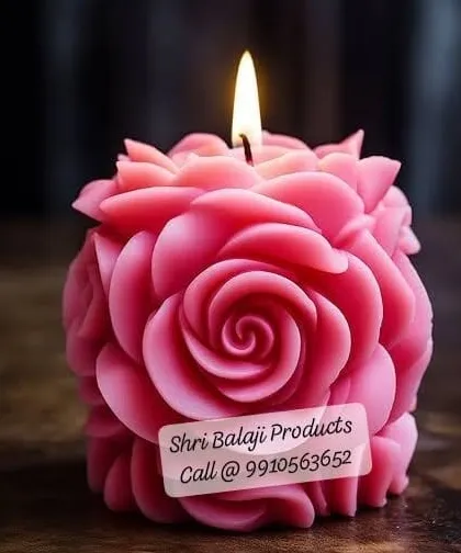 A close-up of a lit, deep pink rose ball candle. The intricate arrangement of petals creates a mesmerizing effect, perfect for a statement decor piece.
