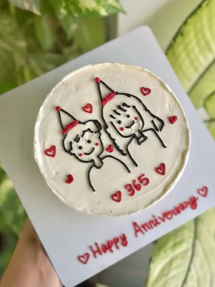 An overhead shot of the "365 days" cake, showing the full design and the "Happy Anniversary" message written on the cake board.