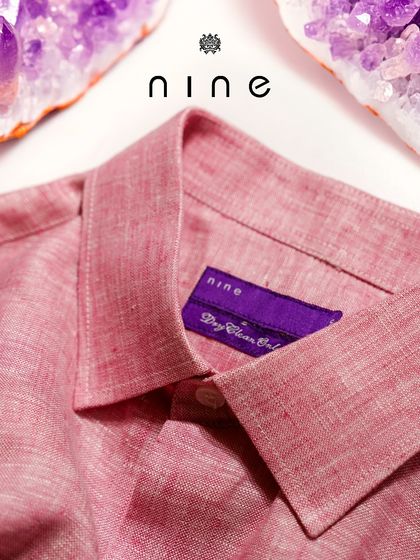 A detailed shot of the salmon pink linen shirt, highlighting the rich color and the texture of the natural fabric.