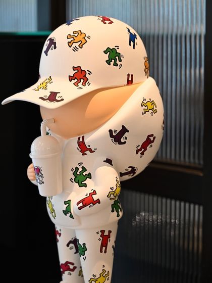 A side profile of the "Kid Cup" sculpture, highlighting its clean lines and the vibrant Keith Haring pattern.
