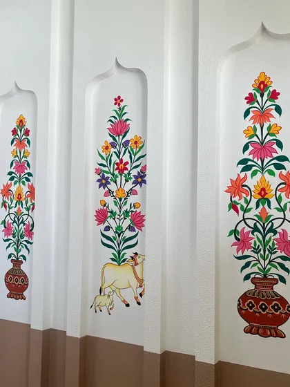 The combination of traditional art with the modern, clean architecture of the pooja room works beautifully.