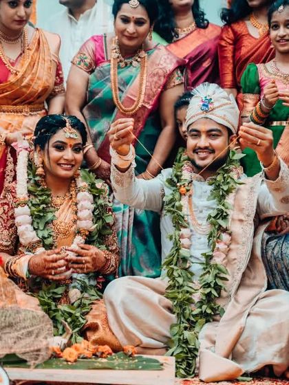 A joyful moment from a wedding ceremony where the couple and their families participate in a ritual together.