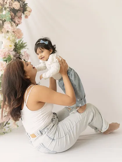 A mother and her baby girl share a moment of laughter and play. This shot captures the fun and carefree side of motherhood.