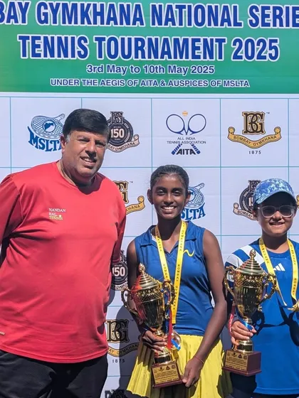 Two champions holding their trophies. Trisha Bhosale and her doubles partner after their victory at the Bombay Gymkhana National Series. We emphasize strong doubles strategy in our training.