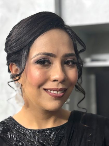 A smiling portrait of the client, showcasing how the glamorous makeup enhances her features and gives her a confident glow.