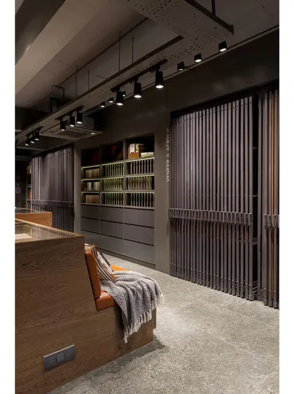 The showroom features multiple display systems, including these sliding panels and open shelving, allowing for a comprehensive and organized presentation of materials.