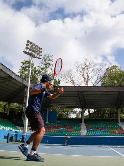 The backhand stroke in motion. This angle highlights the upper body rotation and racquet preparation needed for a clean, powerful shot.