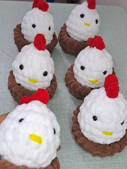 Holding one of the chicken and nest sets to show its cute, handheld size.