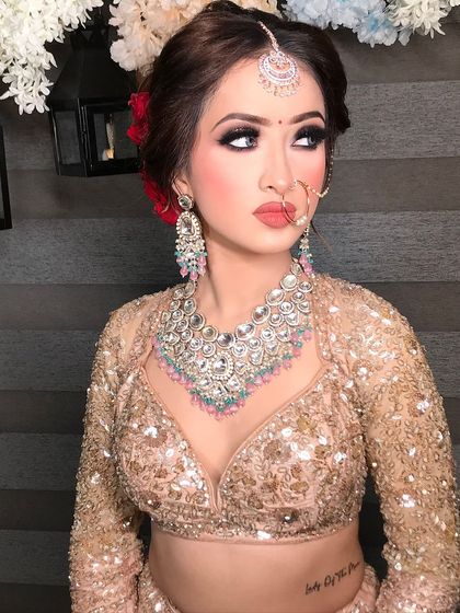 Another angle of this bold and beautiful look. The smokey eyes and heavy jewelry are the stars of the show, balanced by a neutral lip color. The red roses in her hair add a touch of romantic contrast.