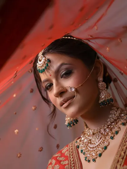 A classic bridal portrait. The focus is on the eyes, which are accentuated with a winged liner and soft shimmer, paired with a traditional bindi and nath.