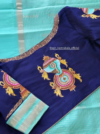 This navy blue blouse features hand-painted 'shankh' (conch) and 'chakra' (discus) motifs, symbols of Lord Vishnu. The pastel colors of the painting create a beautiful contrast with the dark fabric.
