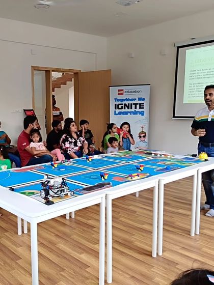 An instructor uses the challenge mat to demonstrate a robotics concept to parents during our LEGO Education orientation.