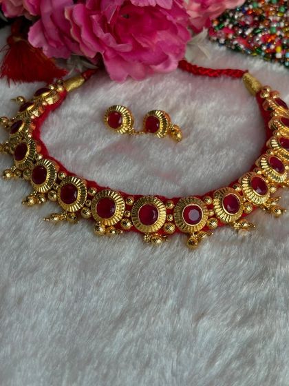 A classic red Maharashtrian thushi necklace with matching earrings. This is a must-have piece for pairing with Paithani sarees for festivals like Ganesh Chaturthi or a wedding.