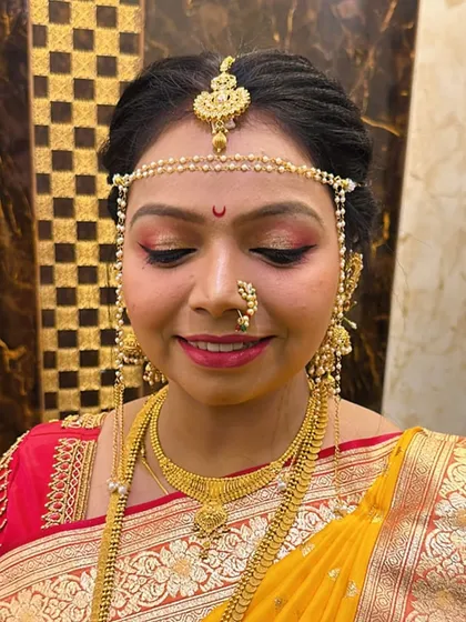 A smiling close-up, showing the traditional 'mundavalya' and 'nath' that complete her bridal look.