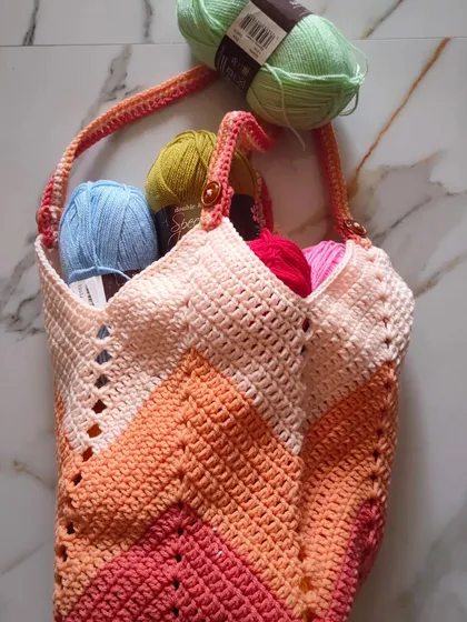 The V-neck shape of the bag is created by the chevron stitch pattern. It's a very satisfying stitch to learn, and I can guide you through it in our one-on-one online classes.