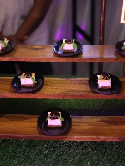 Bite-sized blueberry cheesecakes elegantly presented on individual black plates. This dessert is a perfect single-serving treat for weddings, corporate events, or any upscale gathering.