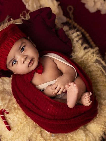 Those eyes are absolutely captivating. This simple, elegant setup with a pop of red allows this beautiful baby's expressive face to be the complete focus of the portrait.