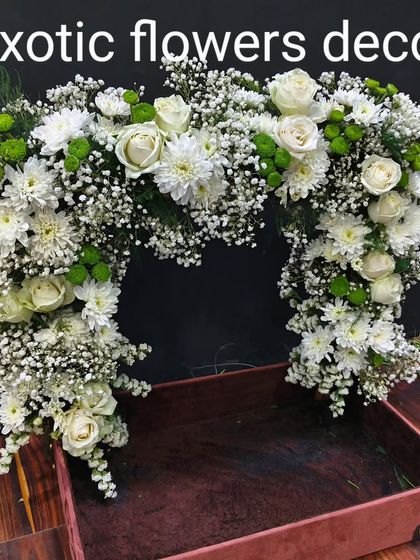 A simple yet beautiful floral arch made of white roses, chrysanthemums, and baby's breath. This piece can be used to frame a deity, an entrance, or as a photo backdrop.