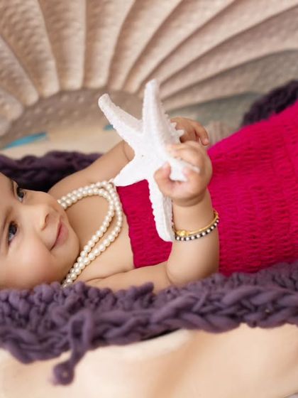 A close-up of our little mermaid relaxing in her clamshell, holding a starfish prop. These detailed shots are perfect for capturing tiny features.
