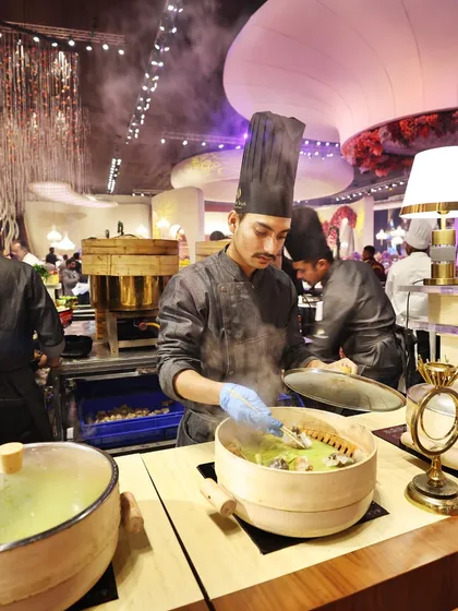 The dim sum station in full swing, with steam rising from multiple bamboo baskets, ensuring a constant supply of these delicate delights.