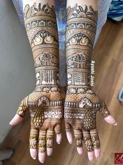 A stunning full-length engagement mehendi featuring majestic peacocks, graceful swans, and rows of tiny elephants, creating a truly royal look.