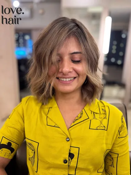 The client smiling, clearly happy with her new short and stylish hair.