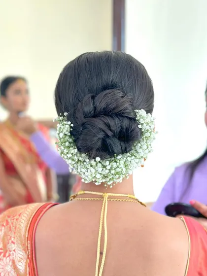 A beautiful bridal bun with a full baby's breath gajra, a classic and elegant choice for any bride.