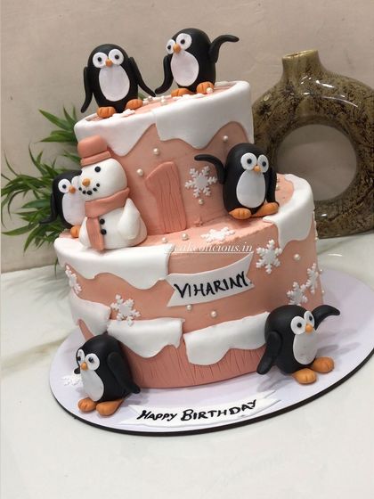 A super cute penguin-themed cake for a first birthday. My client requested a peach color combination with adorable penguins, a snowman, and snowflakes as the main elements. This 3kg cake was a unique Rabri Elaichi flavor.
