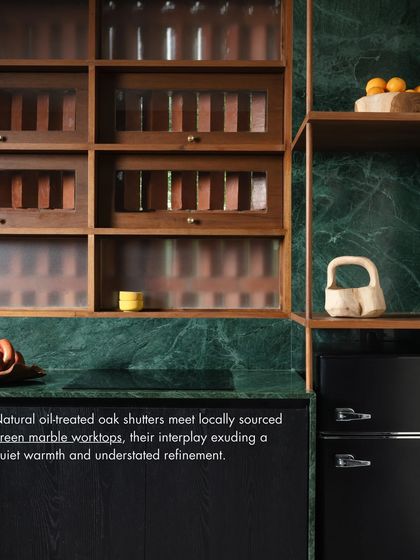 A detail from our biophilic office pantry, where natural oil-treated oak shutters meet locally sourced green marble. This combination exudes a quiet warmth and understated refinement.