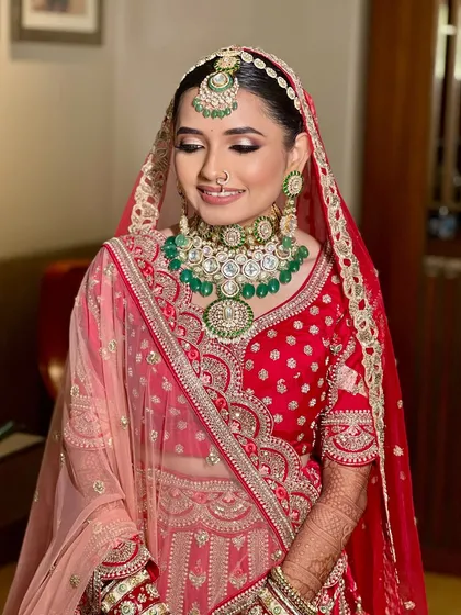 The complete bridal look. This bride is the picture of grace, with her soft makeup, elegant jewelry, and the classic red lehenga coming together perfectly.