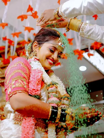 A beautiful, candid shot of the bride during the Akshata ceremony, where guests shower the couple with blessed rice. The genuine smile is what makes this photo special.