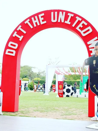 A grand entrance for a football-themed party, featuring an archway and life-sized cutouts of famous football players.