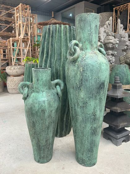 A trio of tall planters in a deep green distressed finish, including two with unique knotted handles.