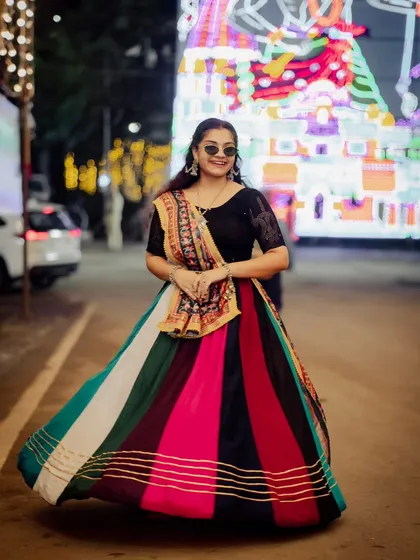 Another dynamic shot of the woman in the multi-colored lehenga, this time capturing the flow and movement of the skirt.
