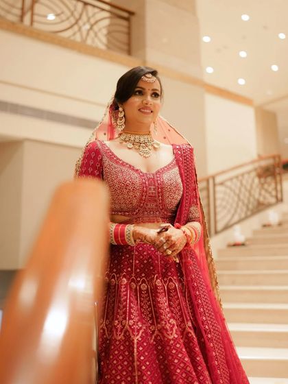 A candid shot of the bride on the staircase, her genuine smile captured as she looks towards the camera.