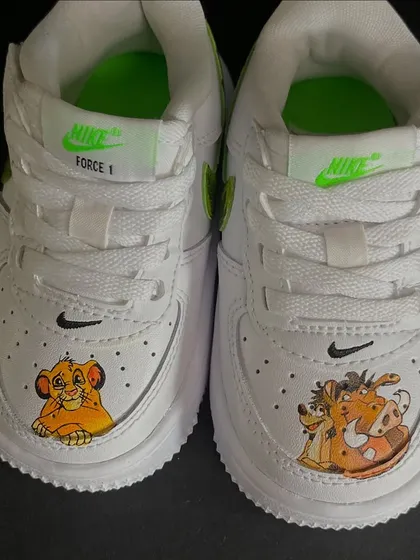 A close-up of the custom Lion King sneakers for kids, featuring Simba and Timon & Pumbaa on the toes.