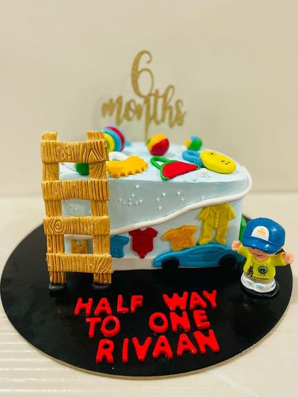 A side view of the "Half way to one" cake, showing the fun details and bright colors perfect for a baby's milestone.