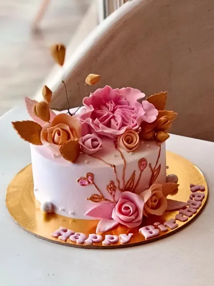 I believe every celebration deserves a beautiful cake. This custom birthday cake features intricate, handcrafted sugar flowers in shades of pink and gold, showcasing the detailed artistry I bring to every personalized order.