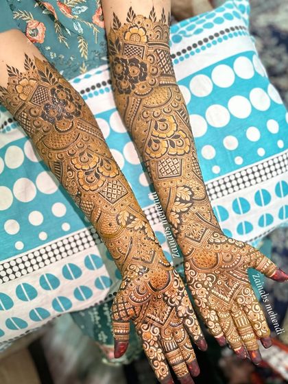 A complete view of Sana's bridal henna, with both arms adorned in a beautiful, symmetrical design.