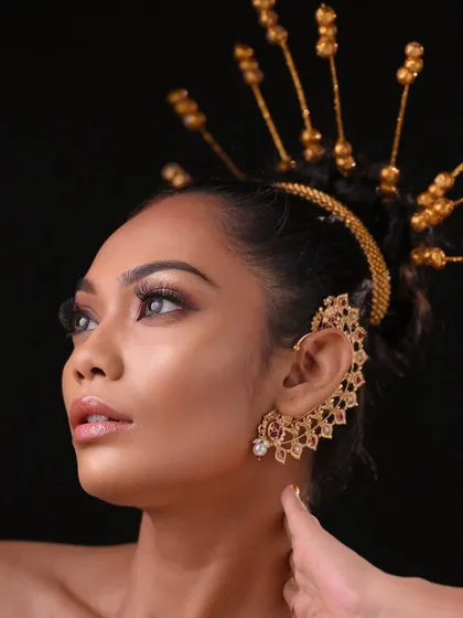 A powerful editorial look featuring a custom gold headpiece and dramatic ear cuff. Students learn to create a full concept, including accessories.