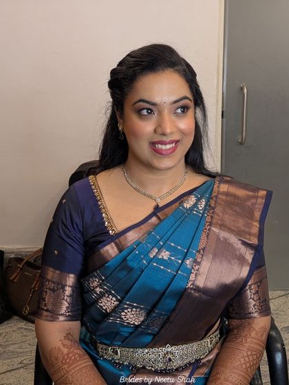 A classic South Indian engagement look. Dressed in a beautiful blue Kanjeevaram saree, her makeup is kept elegant and timeless with defined eyes and a warm skin tone.