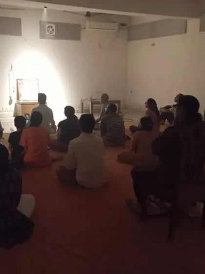 The hall is dark during our Amavasya gathering, with the only light coming from the altar and the screen. This helps to quiet the mind and focus inward.