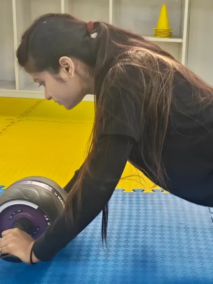 A close-up of a student executing an ab wheel rollout with proper form, a challenging exercise we use to build advanced core strength.