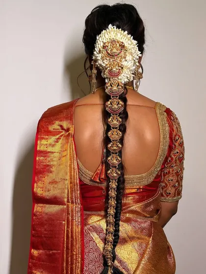 Traditional hair adornments are a key part of the bridal look. This image displays an intricate temple jewellery hair piece, designed to be woven into a braid for an authentic and elegant finish.