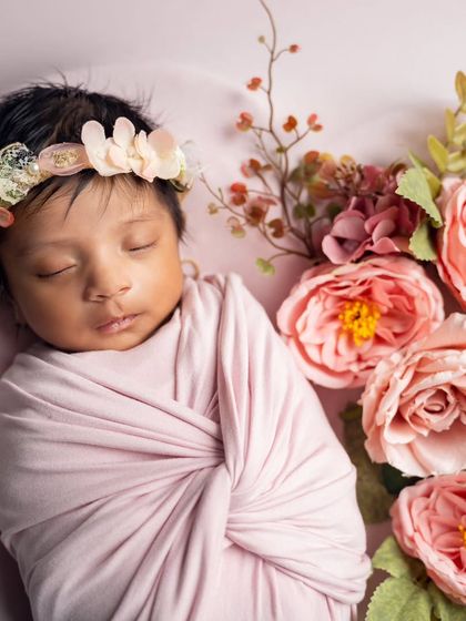 Surrounded by beautiful pink roses, this newborn sleeps peacefully, wearing a delicate floral crown. We love using flowers to add a soft, natural touch.