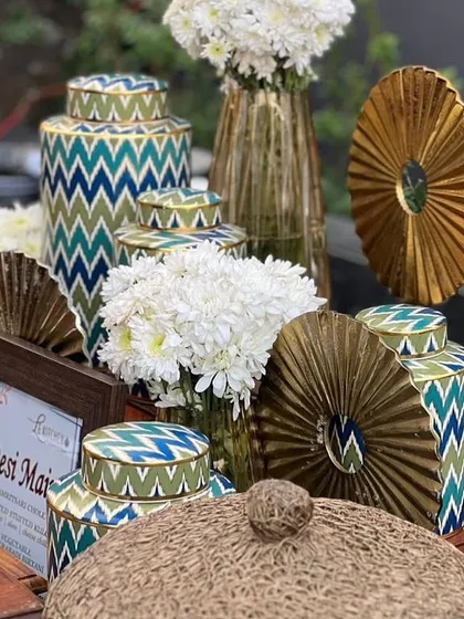 Dreamy decor for a mehendi ceremony, featuring beautiful blue, green, and gold patterned vases and decor pieces.