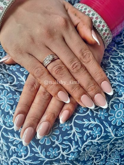 A classic almond-shaped French manicure with a clean white tip and a natural nude base.