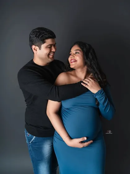 A classic couple's pose from the same session, this time in color. The mom-to-be looks radiant in her blue gown.