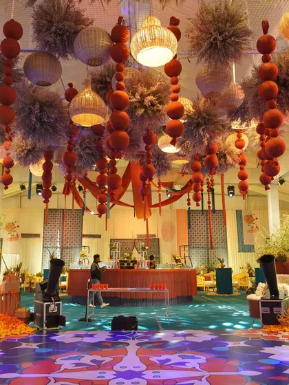 A wide view of the 'Moroccan Nightfall' event, showing the synergy between the deep blues and rustic oranges. The custom dance floor and elaborate ceiling installation created a cohesive and vibrant party space.