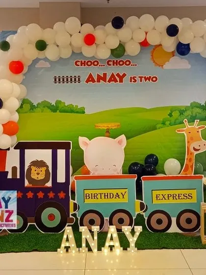 All aboard the birthday express. This creative train theme features a custom backdrop with a "Choo Choo" message, a train cutout carrying cute animals, railroad crossing signs, and marquee letters spelling out the birthday boy's name.